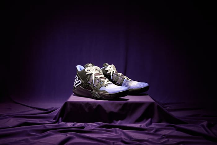 Side view of Coco Gauff's black and purple New Balance tennis shoes.